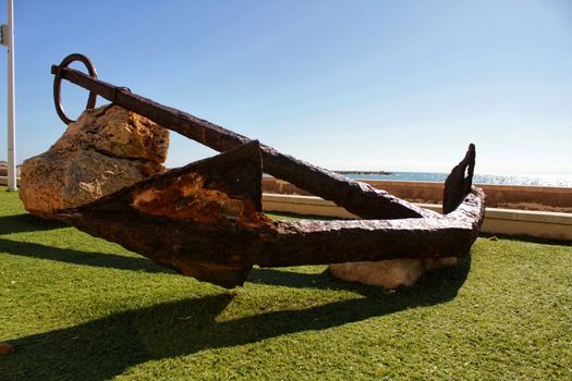 Santa Pola, Spain- February 16, 2018: Old anchor on a promenade of Santa Pola, Alicante. Mediterranean sea on background.