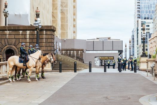 Melbourne, Australia - October 18, 2020: Victoria police patrol Melbourne CBD streets and Parliament on horseback, checking on people during the Coronavirus pandemic and associated lockdown.