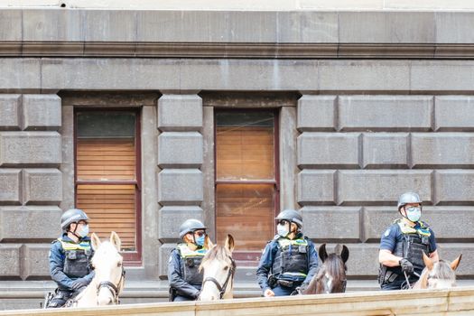 Melbourne, Australia - October 18, 2020: Victoria police patrol Melbourne CBD streets and Parliament on horseback, checking on people during the Coronavirus pandemic and associated lockdown.