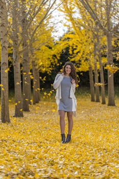 A beautiful brunette model with yellow fall foliage