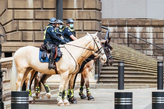 Melbourne, Australia - October 18, 2020: Victoria police patrol Melbourne CBD streets and Parliament on horseback, checking on people during the Coronavirus pandemic and associated lockdown.
