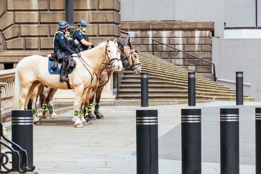 Melbourne, Australia - October 18, 2020: Victoria police patrol Melbourne CBD streets and Parliament on horseback, checking on people during the Coronavirus pandemic and associated lockdown.