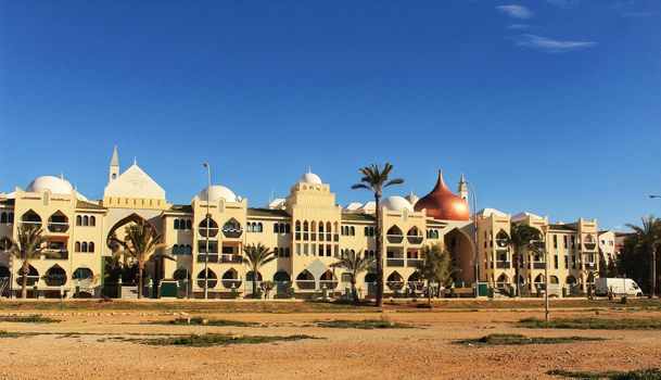 Santa Pola, Spain- February 20, 2018: Beautiful and colorful Arab-style urbanization on the coast of Santa Pola, Alicante, in a sunny day under blue sky