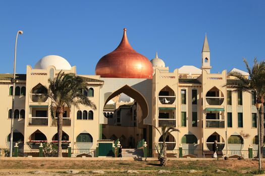 Santa Pola, Spain- February 20, 2018: Beautiful and colorful Arab-style urbanization on the coast of Santa Pola, Alicante, in a sunny day under blue sky