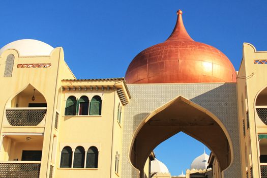 Santa Pola, Spain- February 20, 2018: Beautiful and colorful Arab-style urbanization on the coast of Santa Pola, Alicante, in a sunny day under blue sky