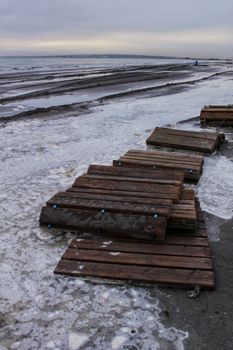 Beach flooded after the storm and broken wooden walkway in Alicante, Spain