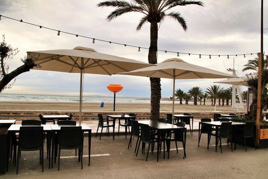 Restaurant with empty terrace on Santa Pola beach in a stormy day