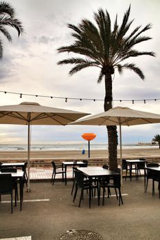 Restaurant with empty terrace on Santa Pola beach in a stormy day