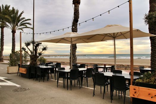 Restaurant with empty terrace on Santa Pola beach in a stormy day