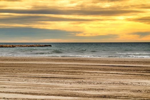 Beach under golden stormy sky in Santa Pola, Alicante, Spain