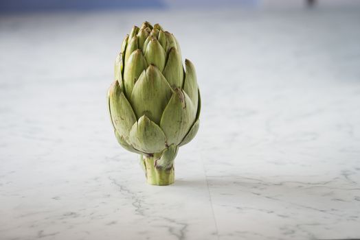 Fresh artichoke on a marble counter