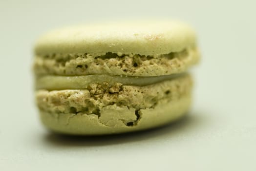 Colored tasty macaroon over a green background.