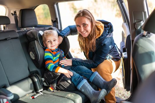 Mother fastening safety belt for her baby boy in his car seat. Children's Car Seat Safety