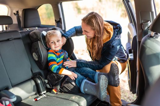 Mother fastening safety belt for her baby boy in his car seat. Children's Car Seat Safety