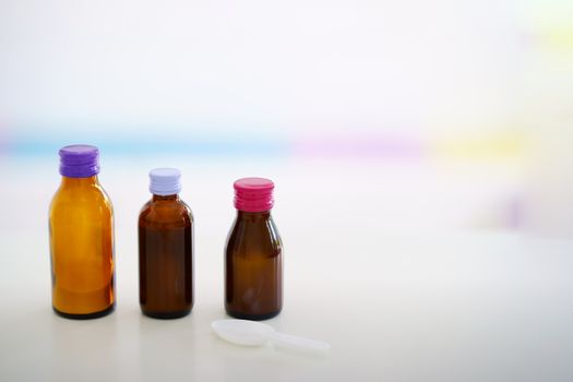Glass drug bottles with colorful caps on blur background