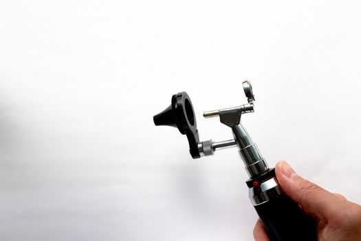 Hand holds Otoscope for ENT doctor exam ear head cone piece view on white background