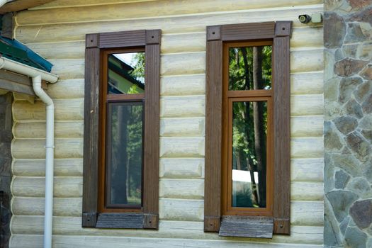 Part of a wooden house. Windows with wooden frame close up.