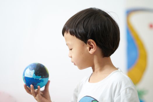 kid is looking at the earth ball for care the environment concept