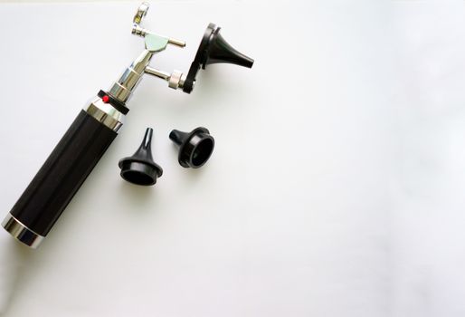 Otoscope for ear check for doctor ENT  with three sizes of specula pieces on blur background with copy space