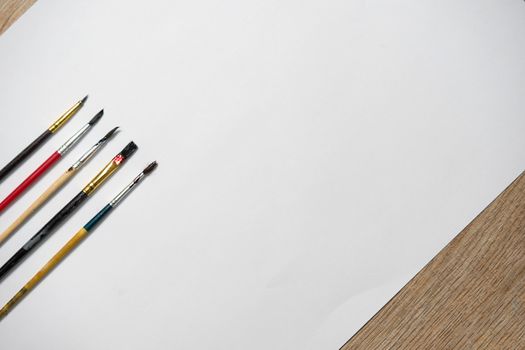 Paper of art work and color brushes,side view