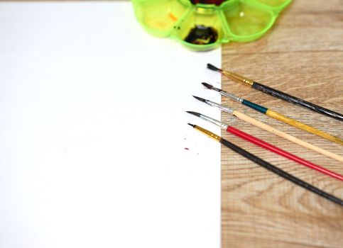 Paper of art work with color plate and color brushes, side view