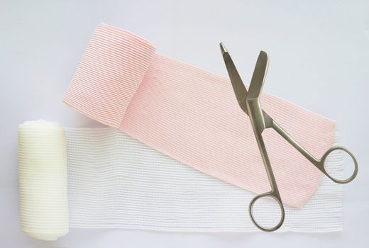 roll elastic bandage or gauze with scissors