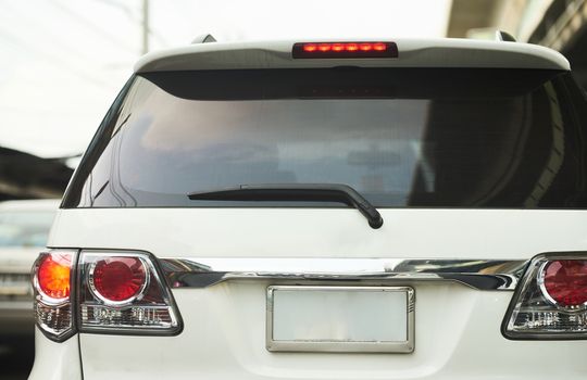 Rear aspect or back view of SUV car in day time real road