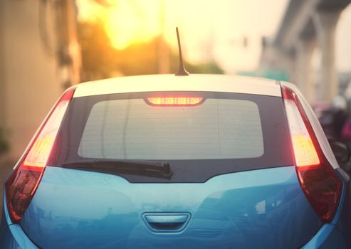 rear car aspect with sun light on blur city background