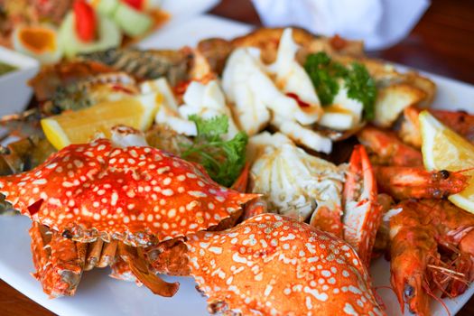 Sea food on big plate include shrimps ,lemon,squid and crab shell