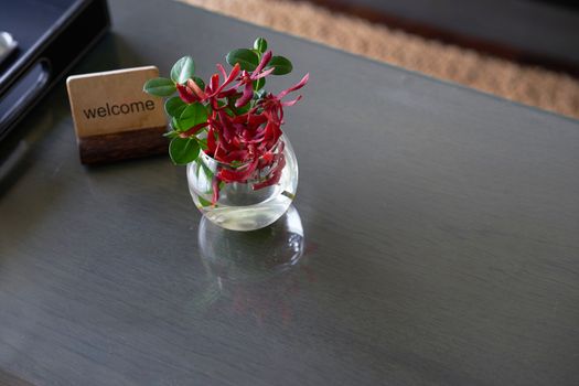 Welcome label stand with flower water vase on table for welcome reception concept