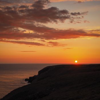 Beautiful orange sunset over a headland on the south Pembrokeshire coast, Wales, UK