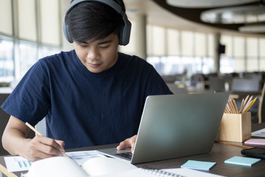 Young collage student using computer and mobile device studying online. Education and online learning. 