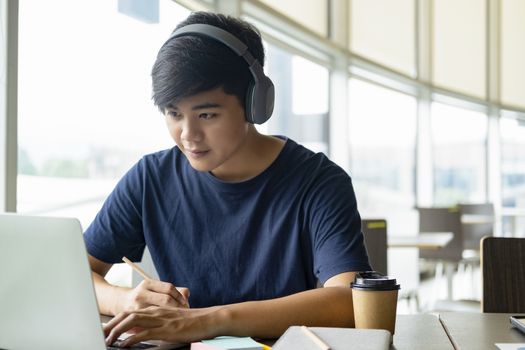 Young collage student using computer and mobile device studying online. Education and online learning. 