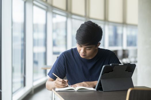 Young collage student using computer and mobile device studying online. Education and online learning. 