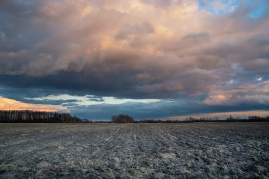 Plowed field and fantastic colorful clouds on the sky, Nowiny, Lubelskie, Poland