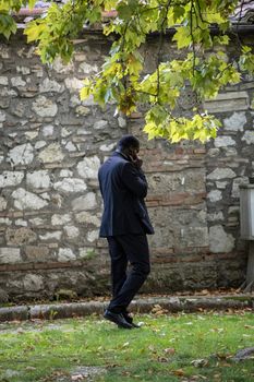 terni,italy october 19 2020:colored parish priest with medical mask and telephone
