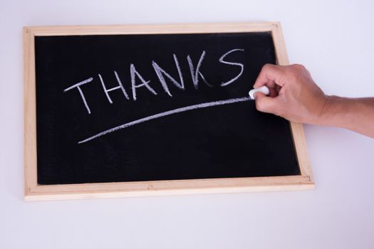 A hand writting thanks with a chalk on a black chalkboard