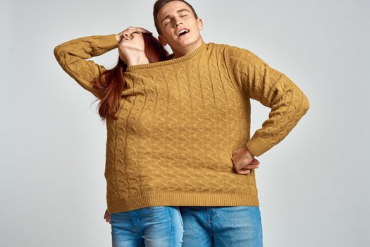 couple in yellow sweater posing against light background cropped view. High quality photo