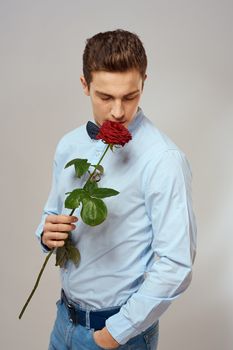 romantic man with red rose and light shirt pants suit. High quality photo