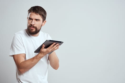 emotional man with tablet in hand touch screen new technologies light background cropped view Copy Space. High quality photo