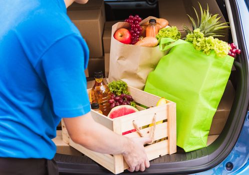 Asian delivery man grocery prepare service giving fresh vegetables food and fruit full in wooden basket on back car to send woman customer at door home after pandemic coronavirus, Back to new normal