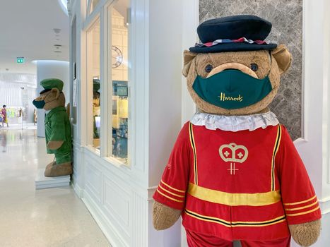 Harrods Teddy Bear (Giant Beefeater Bear) waring mask during Covid-19 pandemic at entrance of famous Harrods store in Central Embassy, Bangkok, Thailand