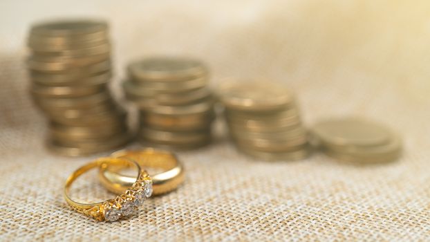 Wedding rings with stack of coins, saving money for marry.