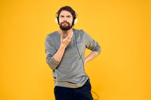 Man with headphones music lifestyle lifestyle technology yellow background. High quality photo