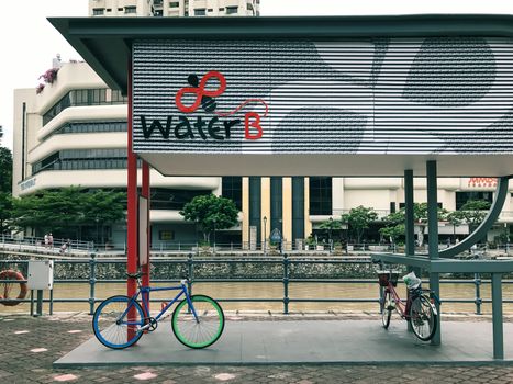 Bicycle parked at Water B ticketing kiosk for Singapore River Cruise by the river in Singapore city.  It is a good way to explore many iconic landmarks of Singapore city.