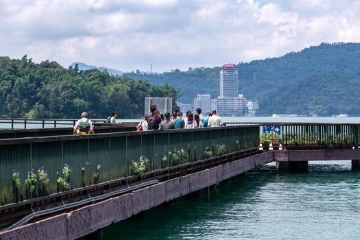 Tourists walk on pier for Hop-On Hop-Off Boat at Sun Moon Lake, the largest lake in Taiwan and tourist attraction. There are 3 main piers at Sun Moon Lake.