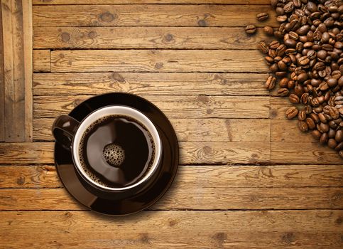 Cup of black coffee and roasted beans on old weathered wooden plank table background, top view