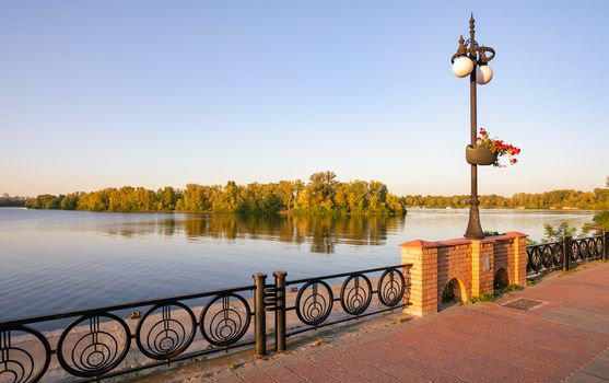 Promenade along the Dnieper River in the Obolon district of Kiev, Ukraine, on a sunny summer evening