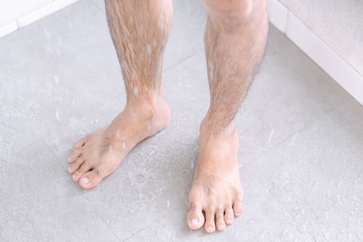Close up man legs with taking a shower in the bathroom, health care and beauty