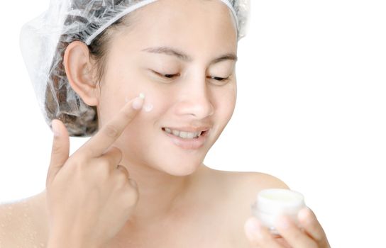 Woman hand applying cream on her face with happy feeling, health care and beauty concept